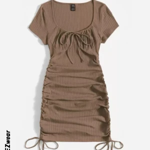 Brun ribbad klänning - Snygg brun ribbad klänning med korta ärmar och knytning framtill. Klänningen har en åtsittande passform med rynkade detaljer på sidorna och justerbara band nedtill. Väldigt stretchig, passar nog upp till L. Perfekt för en sommardag! Köpt för flera år sedan, säljer då jag inte använder. Endast använd 2 gånger! Skriv för fler bilder!