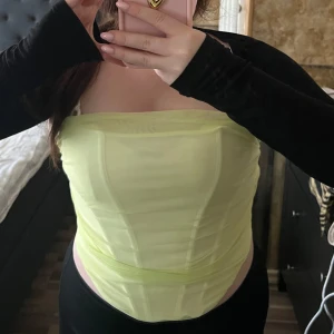 Ljusgrön tubtopp - Säljer en stilren ljusgrön tubtopp. Perfekt för sommardagar eller en utekväll. Toppen har en enkel och elegant design som framhäver axlarna.