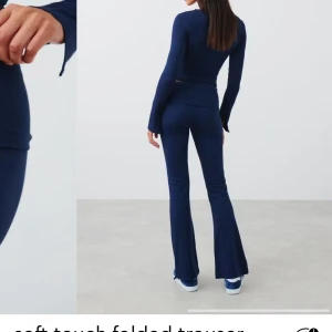 Mörkblå mjukisbyxor - Snygga mörkblå mjukisbyxor med bootcut-stil. Byxorna har en hög midja och är tillverkade i ett mjukt material som ger en bekväm passform. Perfekta för en avslappnad look.