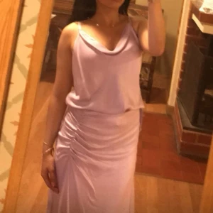 Ljuslila axelbandslös klänning - Elegant ljuslila klänning med draperad topp och smickrande passform. Perfekt för sommarens fester.