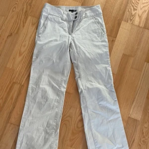 Beige byxor från H&M - Snygga beige byxor från H&M med två knappar i midjan och praktiska fickor. Perfekta för en stilren look.