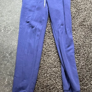 Lilla mjukisbyxor från Champion - Snygga Lilla mjukisbyxor från Champion i storlek S. Byxorna har en bekväm passform med resår i midjan och muddar vid bensluten. Perfekta för en avslappnad stil. 🩵