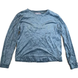 Blå/ljus grå tröja från Juicy Couture - Säljer en blå långärmad tröja från Juicy Couture med textdetalj på framsidan.