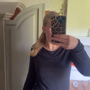 Svart långärmad topp från 157 - En svart långärmad topp från 157 med enkel och clean design. Tunt och mjukt material som sitter skönt mot kroppen. Perfekt att styla med jeans eller kjol för en chill look. Snyggt rundad halsringning.