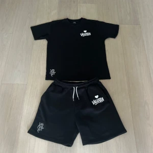 Valerra summer set - sommarset från Valerra, bestående av matchande T-shirt och shorts. Setet har en minimalistisk design med en broderad logga på bröstet och en större tryckt logga som ger en modern touch.  Materialet är av premiumkvalitet – huvudsakligen bomull – vilket gör det både bekvämt och perfekt för varma dagar. Det här setet är en del av en exklusiv drop och kommer med största sannolikhet inte att släppas igen i år.  Perfekt för dig som gillar stilrena, street-inspirerade plagg med hög kvalité!