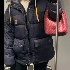 Mörkblå dunjacka från Fjällräven - Väl använd med ett litet hål på vänster arm