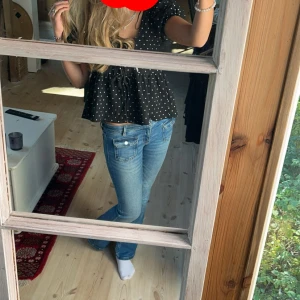 Svart prickig blus från Gina Tricot - Supersöt svart blus med vita prickar från Gina Tricot. Modellen har puffiga korta ärmar, mer två rosetter man knyter fram💗 använd ett fåtal gånger💗