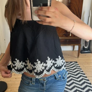 Svart linnetopp  - Svart linnetopp från H&M Divided med tunna axelband och vit broderad spetskant nertill. Knappt använd och är som ny! Pris kan diskuteras!