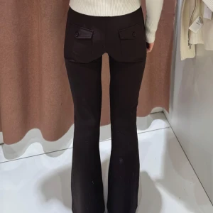 Bruna bootcut byxor från Gina Tricot - Midja: 75cm, innerben: 84cm ⊹ Snygga bruna bootcut-byxor från Gina Tricot med två knappar i midjan och fickor med lock bak. Byxorna har en figurnära passform upptill och utsvängda ben. Perfekta för dig som gillar en trendig och stilren look. ⊹ jag är 173cm & stl S/36/28 för referens ⊹ läs POLICY (i gillade inlägg) innan köp ⊹ använd gärna ”Köp” ⊹ 