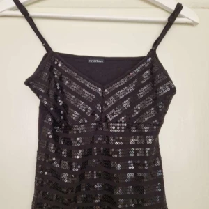 Svart paljett/glittrig topp från Motivi - Snygg svart festtopp från Motivi med smala axelband och v-ringning. 