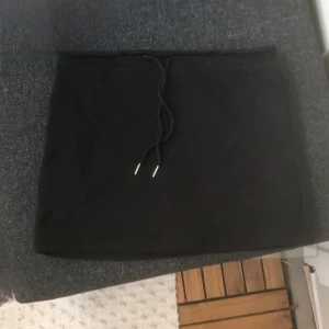 svart mjukisshorts  - En svart kortkjol och mjukisshorts med snörning i midjan och shorts under kjolen. Materialet är inte så stretchig men lite, den är som materialet lite tunnare mjukisbyxor men i shorts. Den är i storlek L men passar absolut inte L jag har M men ville den skulle va lite over zize men den är för liten för mig.