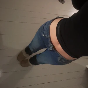 Supersnygga blå jeans - Supersnygga mörkblåa jeans med orange/brun brodyr på fickorna. Tyget är lite annorlunda mot hur jeans brukar kännas eftersom det är lite tunnare. Lite stora i midjan för mig som brukar ha XS/S i jeans men det är inget jag tänkt på när jag använt dom. Dessa jeans är perfekta för dig som är lång eftersom de är för långa för mig som är 170 cm! Lite slitna som ni kan se nere vid benen men skulle inte säga att det är något man tänker på. Priset kan diskuteras.