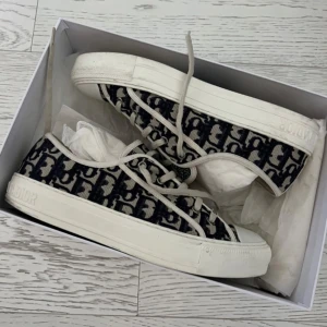 Dior sneakers - Säljer ett par dior sneakers med det klassiska dior monogrammet, gjorda av bomull. Använda men mycket välskötta. Passar storlek 41 men funkar även för 40. Bild på kvitto finns! Box medföljer🌟