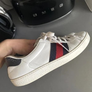 Gucci Ace Sneakers - Gucci ace skor äkta kan även mötas upp i stockholm,  Skorna är vita med mörkblå och röda detaljer. Pris kan diskuteras
