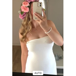 Vit tubklänning ginatricot  - Snygg vit axelbandslös tubklänning med tight passform och midilängd. Klänningen är enkel och stilren, perfekt för dig som gillar minimalistisk look. Storlek 38 