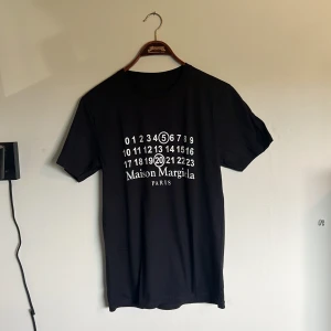 Maison marigiela t shirt - Riktigt fet och eftertraktad Maison margiela t shirt i storlek S! Helt nytt skick! Lite osäker på äktheten så därför är priset just nu på 699kr nypris runt 3000kr! Tveka inte med att ställa frågor! 