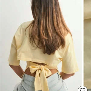 Intresskoll på en gul knyt topp från Nelly - Säljer en ljusgul croppad topp med korta ärmar och snygg knytning i ryggen. Perfekt för varma dagar och enkel att styla med jeans eller kjol. Mjuk och skön bomullskänsla. Slutsåld topp från Nelly