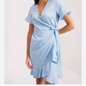 Ljusblå omlottklänning med prickigt mönster - Söt sommarklänning. Klänningen är endast använd en gång💕