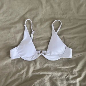 Vit bikiniöverdel med bygel - Snygg vit bikiniöverdel med bygel. Köpt i mycket gott skick från Sellpy och aldrig använd av mig då den inte passade. Storlek M med justerbara band och spänne i ryggen. Inlägg finns som också går att ta ut. Skriv gärna vid frågor!🤗