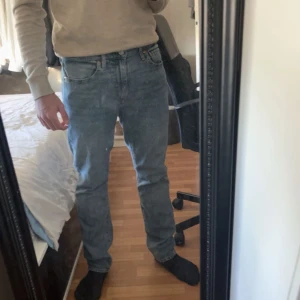 Blå raka jeans från Levi's - Klassiska blå jeans från Levi's med rak passform och normal midja. Jeansen har fem fickor och stängs med dragkedja och knapp. Perfekta till vardags och passar till det mesta.