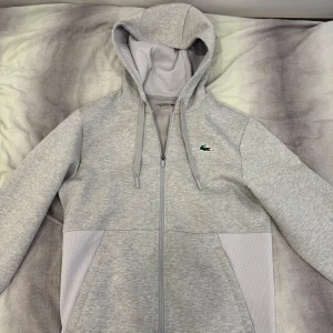 Lacoste Kofta - Lacoste kofta, använd men fåtal gånger men är precis som i nytt skick. Köptes från zalando runt 2000kr under vintern. Pris vid snabb affär kan diskuteras.
