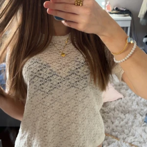 Vit spetsblus - Säljer en söt vit blus i spets med korta ärmar. Blusen har ett feminint mönster och är lätt transparent, perfekt att styla med ett linne under. Avslappnad passform och rund halsringning. aldrig använd