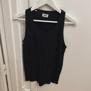 Svart ribbad linnetopp från Réunion - Säljer en svart ribbad linnetopp från Réunion i storlek medium. Toppen är ärmlös med rund halsringning och har en enkel, stilren design som passar perfekt till sommaren.