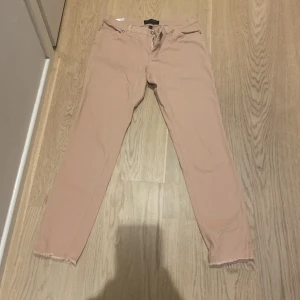 Beiga slim fit jeans från Bodyflirt - Säljer ett par beiga slim fit jeans från Bodyflirt i storlek 36. Byxorna har råa benslut och klassisk femficksdesign. Perfekta för dig som gillar en enkel och stilren look.