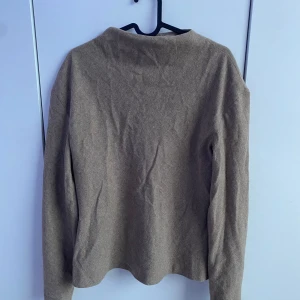 Beige ulltröja från Zara - Säljer en stilren beige tröja från Zara i storlek L. Tröjan är tillverkad i ullmaterial och har lång ärm. Perfekt för dig som gillar en klassisk och enkel look men ändå har tjöjan en unik stil för att få lite extra detaljer.