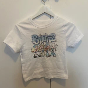 Vit Bratz t-shirt med tryck - Croptop med Bratz tryck, köpt på Forever 21 i LA! Aldrig använd 💓
