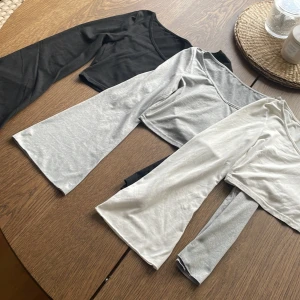 3-pack långärmade toppar från SHEIN - Säljer tre långärmade toppar från SHEIN i färgerna svart, grå och vit. Alla har en croppad passform och är tillverkade i mjuk bomullsmix. Perfekta att matcha med jeans eller kjol för en enkel och stilren look.