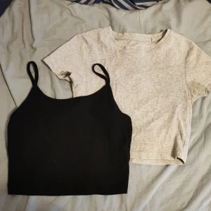 Svart ribbad linnetopp & grå t-shirt från FB Sister - Två toppar från FB Sister: en svart ribbad linnetopp med smala axelband och en grå t-shirt med kort ärm och diskret mönster. Perfekta att matcha tillsammans eller var för sig!