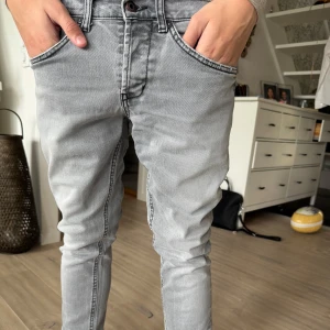 George dondup - Snygga grå dondup med smal passform. Byxorna har normal midja och raka ben med diskreta sömmar. Perfekta för en stilren vardagslook.