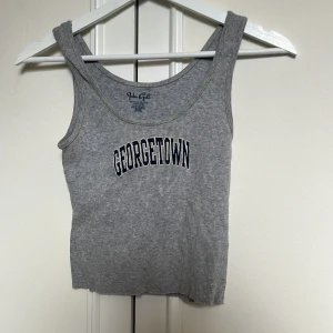 Grå ribbad crop top - Grå ribbad linnetopp från Brandy Melville med trycket 'Georgetown' framtill. 
