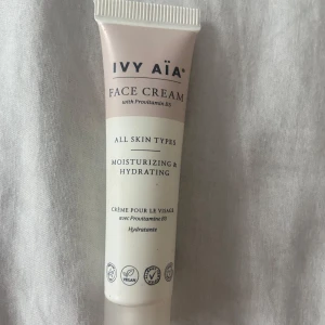 IVY AIA Face Cream med Provitamin B5 - Återfuktande ansiktskräm från IVY AIA med Provitamin B5, passar alla hudtyper. Tuben är ljusrosa och vit, innehåller 15 ml och är tillverkad av 98% återvunnen plast. Vegansk och allergivänlig formula, perfekt för daglig hudvård. Cirka 10 ml kvar