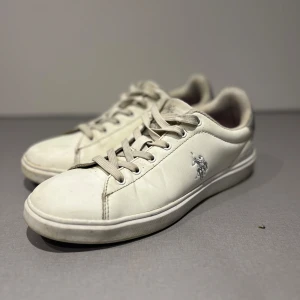 Ralph Lauren sneakers - Jätte fina vita Ralph Lauren sneakers med silvrig logga. Använda men bra skick. Lite små hål i sulan men inget som man tänker på🥰