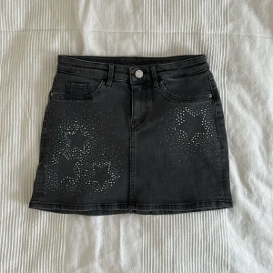 supersöt svart minikjol med detaljer - härlig kjol med paljetter i mönster av stjärnor. perfekt för att piffa upp sin outfit lite extra.