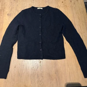 Marinblå kofta från Gina Tricot  - Mysig marinblå kofta från GinaTricot med rund hals och knappar framtill. Klassisk och enkel design med långärmade ärmar 🥰