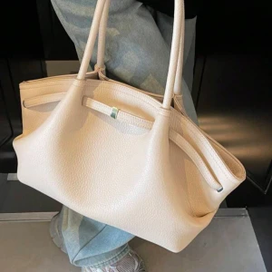 Beige handväska i skinn  - Råkade beställa två av denna väskan därav jag säljer, har inte kommit än men vill ni ha mina egna bilder så skickar jag det när väskan kommit! Kommer helt oanvänd! Väskans mått är 31x22 plus axelremmen då på ca 20 cm. Man får plats med både dator och massa annat då den är väldigt rymlig (min vän har likadan därav jag vet det) så den är perfekt till skolan, vardagen och jobb💕skriv om ni är intresserade eller har frågor så svarar jag på allt jag kan💕