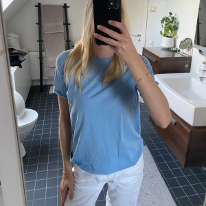 Ljusblå basic t-shirt  - Enkel och fräsch ljusblå t-shirt med rund hals och korta ärmar. Modellen är rak och har en avslappnad passform, perfekt till jeans eller shorts. Tillverkad i mjuk bomull som känns skön mot huden. Stilren och lätt att matcha med det mesta.