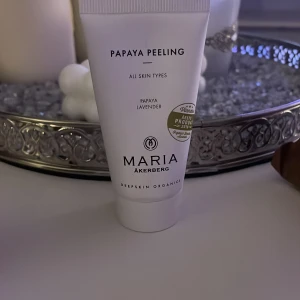 Papaya Peeling från Maria Åkerberg - Papaya Peeling från Maria Åkerberg är en ansiktspeeling med papaya och lavendel, passar alla hudtyper. Kommer i en vit tub med svart text och guldmärke. Ekologisk och prisbelönt produkt för fräschare hud.