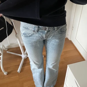 Ljusblå raka jeans med fickdetaljer - Säljer ett par ljusblå jeans med raka ben och snygga fickor med lock och knapp bak. Jeansen har klassisk femficksdesign, låg midja och är i mjukt denimtyg. Perfekta för en chill och avslappnad look. Pris kan diskuteras vid snabb affär💗