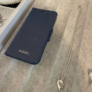 Marinblått mobilskal - Marinblått mobilskal till iPhone 12 mini & 13 mini. Finns fack inuti för att förvara tex visakort. 