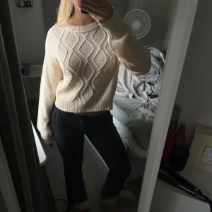 Beige stickad tröja med mönster - Supermysig beige stickad tröja med snyggt strukturmönster framtill. Tröjan har en croppad passform, rund halsringning och långa ärmar. Passar dig som gillar en enkel men ändå trendig look 🩷