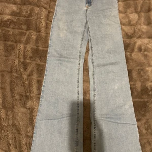 Ljusblå highwaist bootcut jeans  - Jeansen har hög midja, klassiska bakfickor och är tillverkade i mjukt denimtyg. 