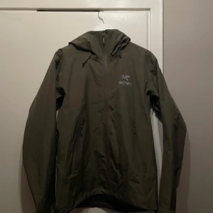 Arc'teryx Beta LT Regnjacka - Beta LT skaljacka med Tatsu grön färg, ett måste köp för dig som vill skydda dig mot otrevliga väder som regn och snö. Med denna jacka kan du fritt vara ute utan att behöve tänka på vädret. i perfekt skick. Inga hål eller slitage.  🚨🚨🚨PRIS KAN DISKUTERAS ENDAST FÖR SERIÖSA KÖPARE‼️‼️‼️‼️