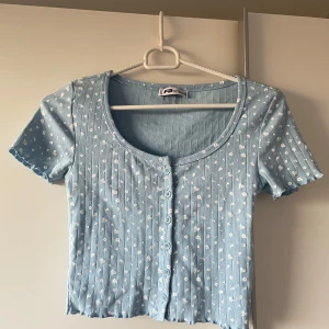 Blommig ljusblå croppad topp - Supersöt ljusblå croppad topp från FB sisters med små vita blommor och ribbad struktur. 