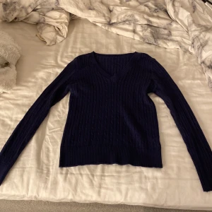 Mörkblå stickad v-ringad tröja - Snygg mörkblå stickad tröja med v-ringad hals och kabelstickat mönster.  Figur sydd. Storlek xs 🩷Helt ny !!!!
