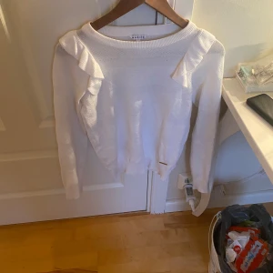 Tröja  med volang  - En vit tröja med volang vid axlarna. Den är i väldigt bra skick 