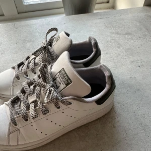 Adidas Stan Smith unika  - Säljer ett par unika skit snygga stan smith med mörkgröna detaljer samt skit snygga mönstrade snören😍Den ända defekten är inne i skon på hälarna ( sid 5), vilket inte syns vid använding.